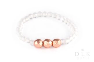 A rock crystal elastic ring with three pink faceted hematites