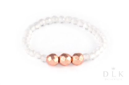 A rock crystal elastic ring with three pink faceted hematites