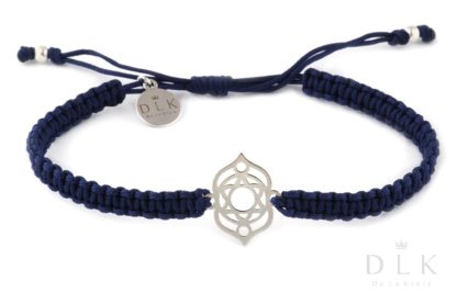 A bracelet with a silver third eye chakra on a navy blue macrame
