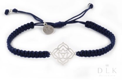 A bracelet with a silver base chakra on a navy blue macrame