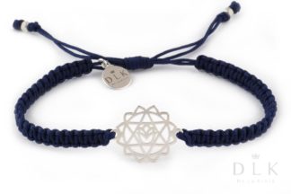 A bracelet with a silver heart chakra on a navy blue macramé