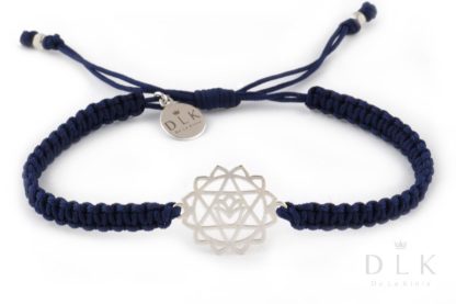 A bracelet with a silver heart chakra on a navy blue macramé