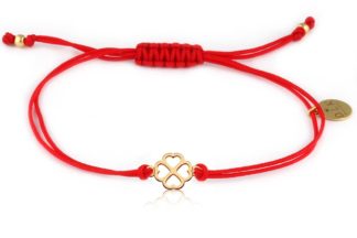 Bracelet with golden clover in hearts on a red string