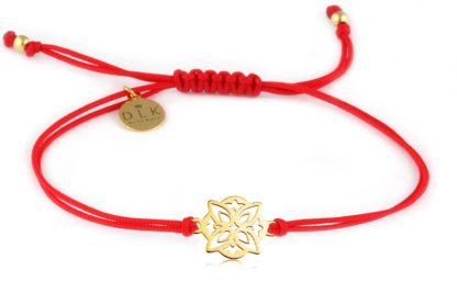 Bracelet with decorative golden rosette on a red string