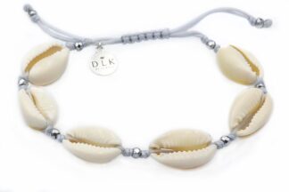 A bracelet with Kauri shells on a light gray string