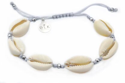 A bracelet with Kauri shells on a light gray string